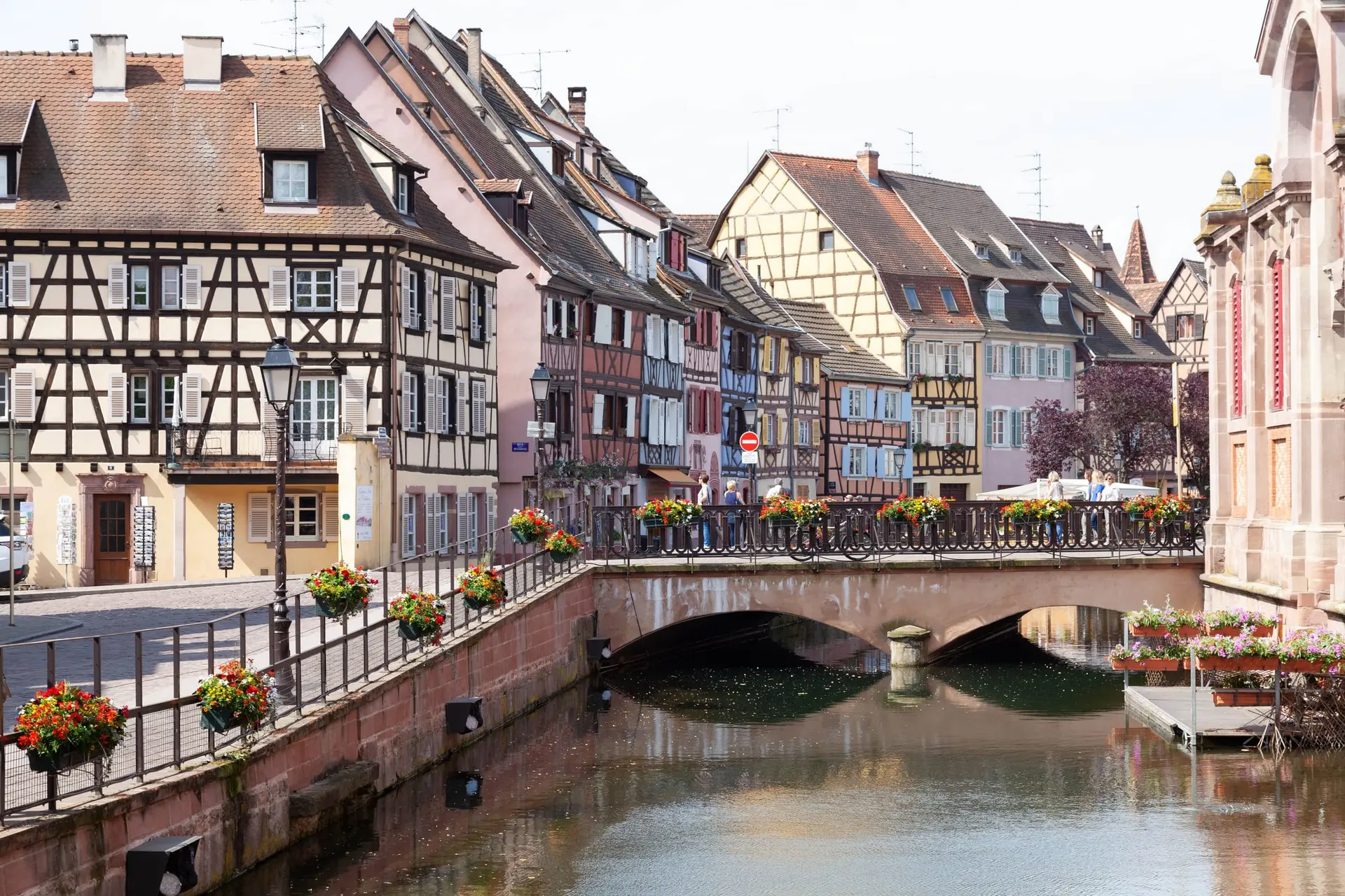 La Petite Venise à Colmar : maisons à colombages colorées et pont fleuri au-dessus du canal.