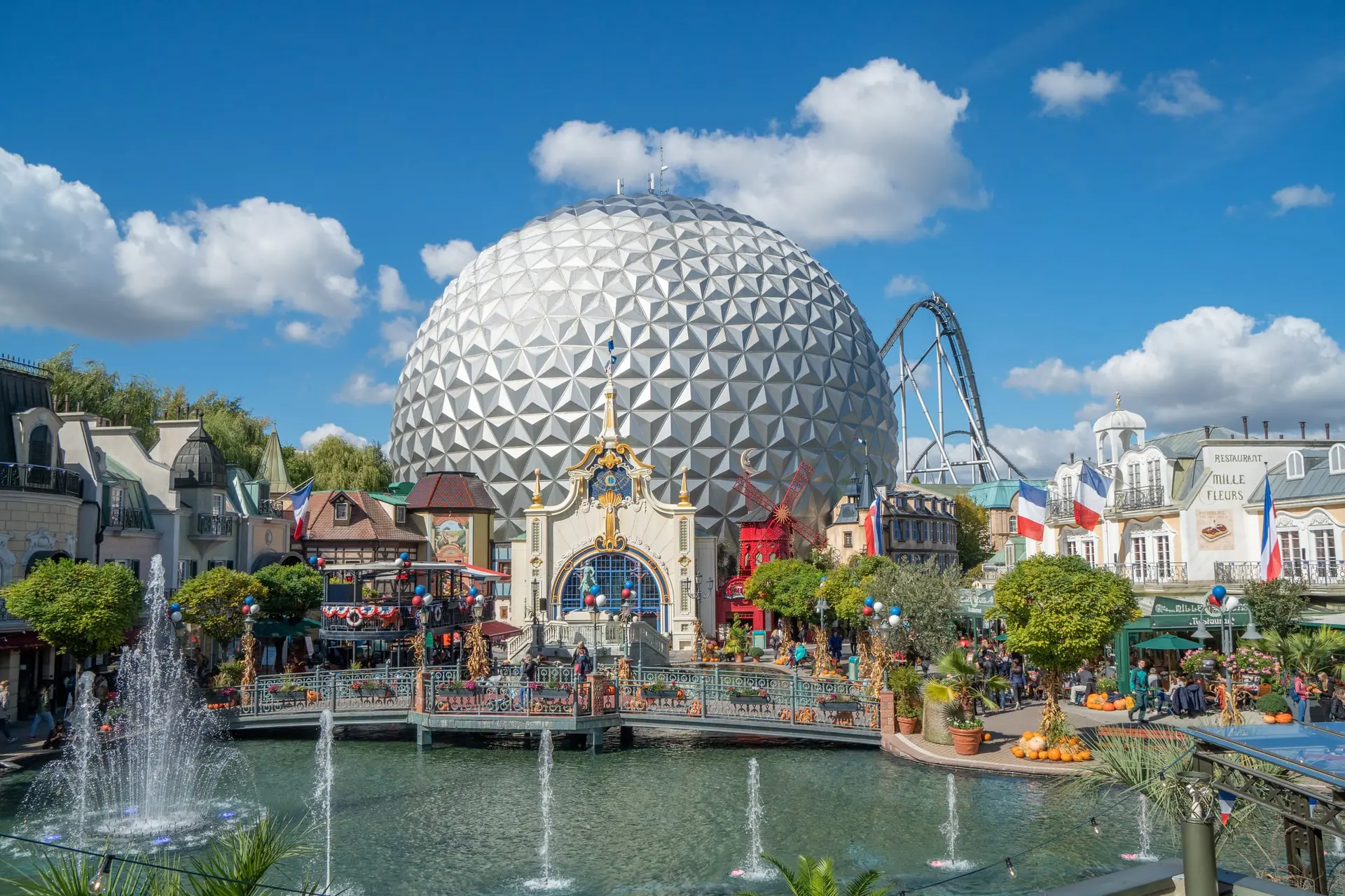 Le dôme argenté d'Europa-Park et ses fontaines, avec des montagnes russes en arrière-plan.